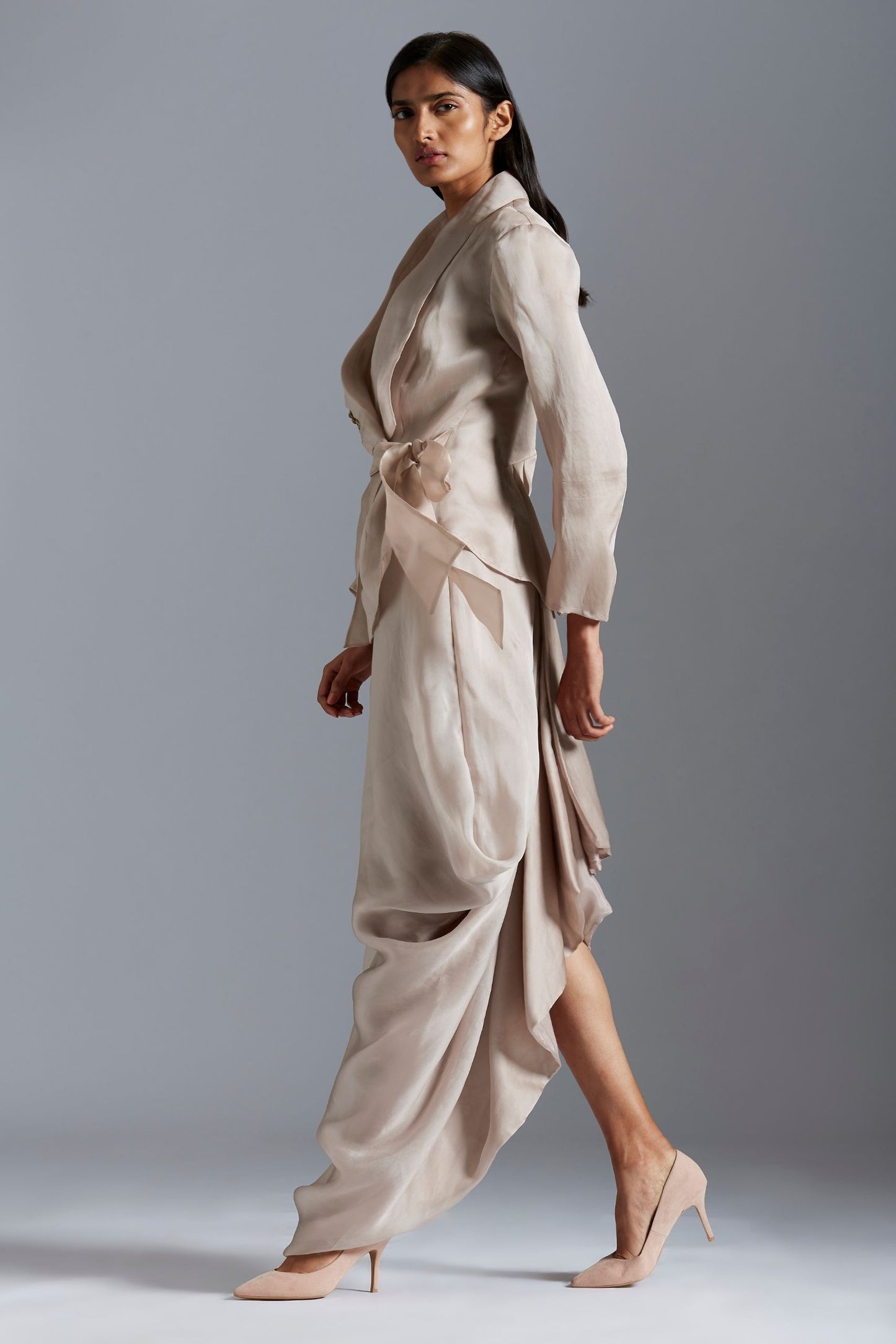 Woman confidently wearing the designer jacket with drape skirt, perfect for an elegant and stylish occasion