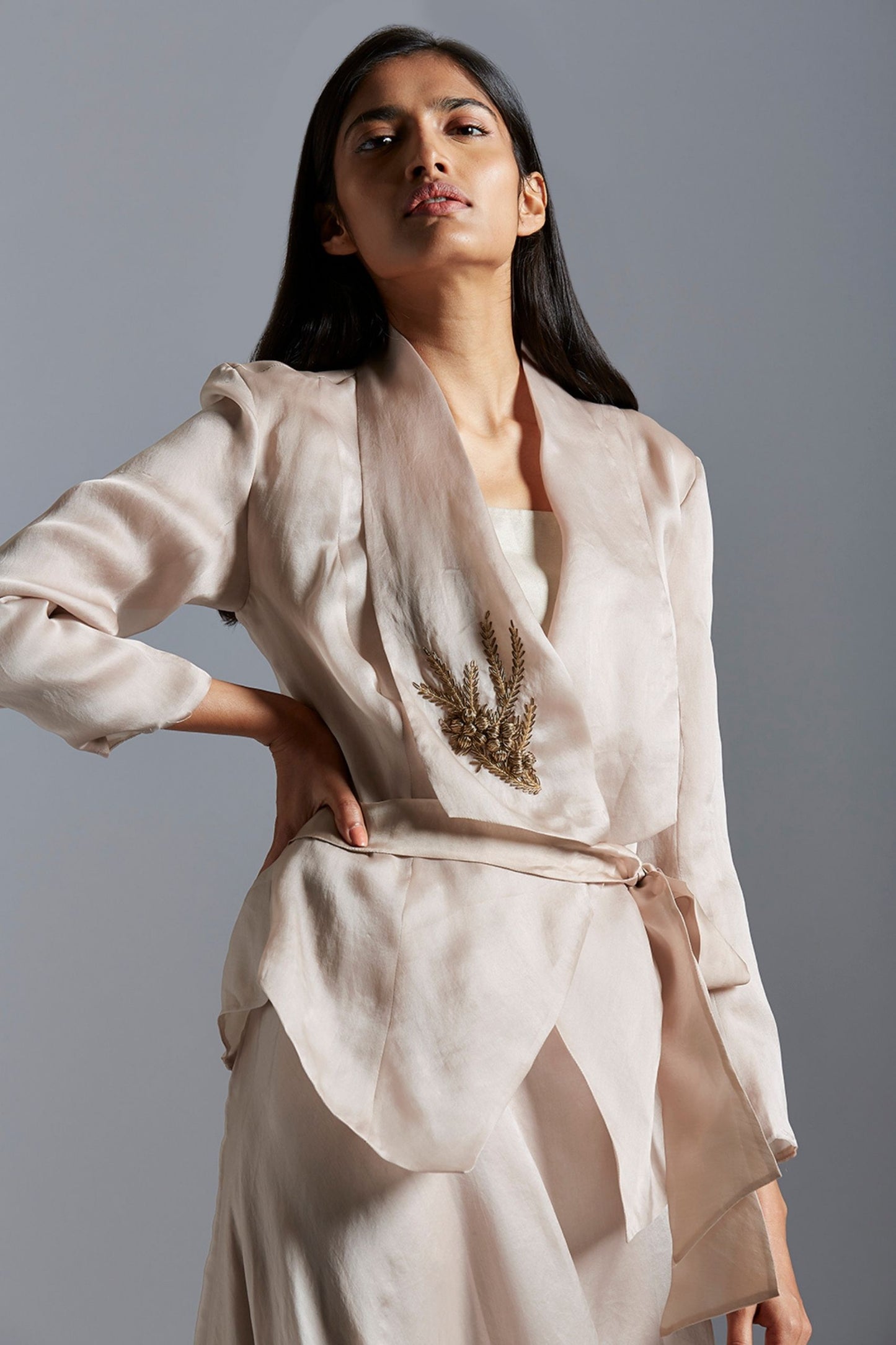 Close-up of the metallic embroidery details on the designer jacket, showcasing fine craftsmanship