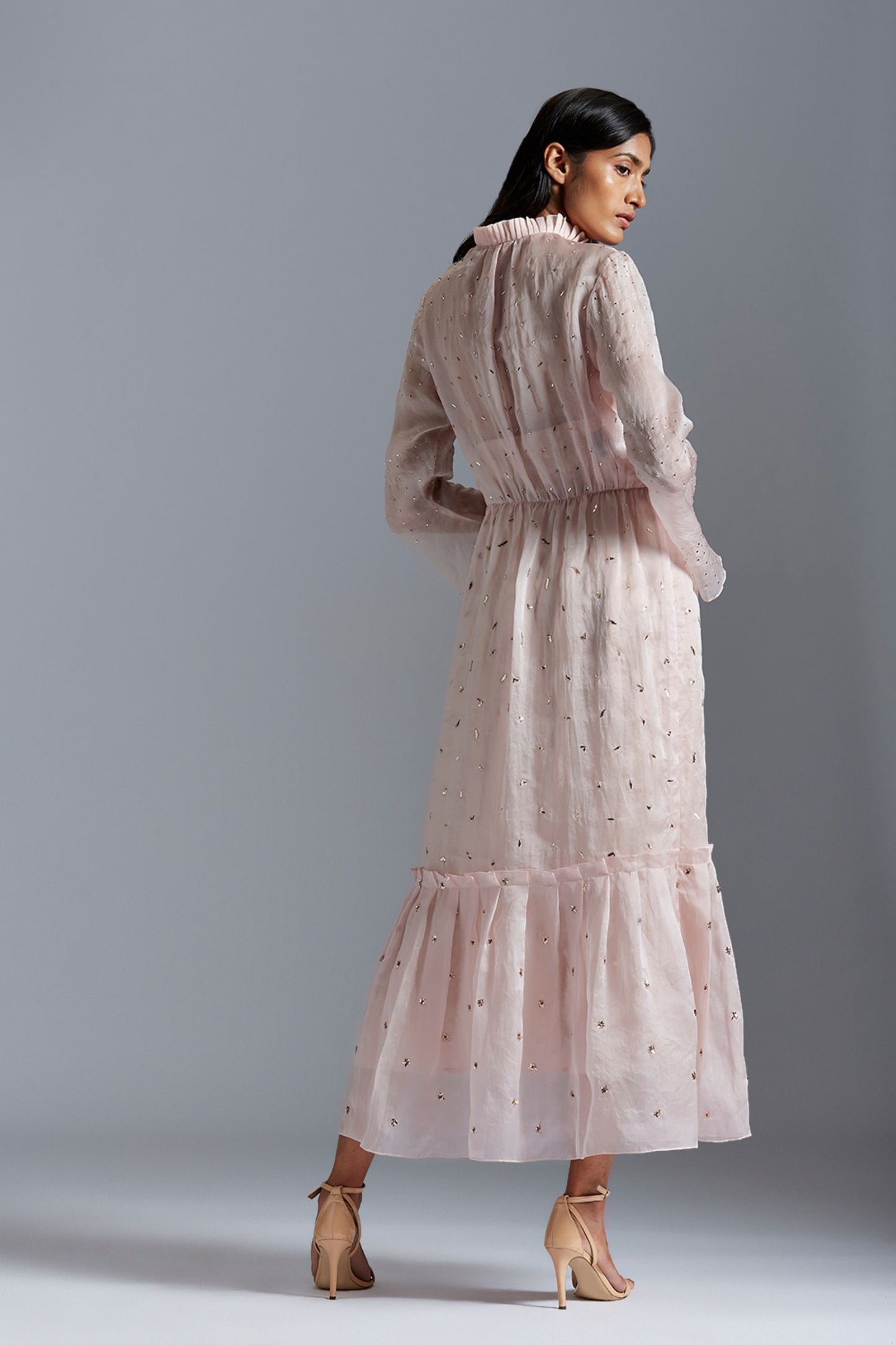 Back view of women’s sheer maxi dress showcasing satin organza fabric and Victorian sleeve design
