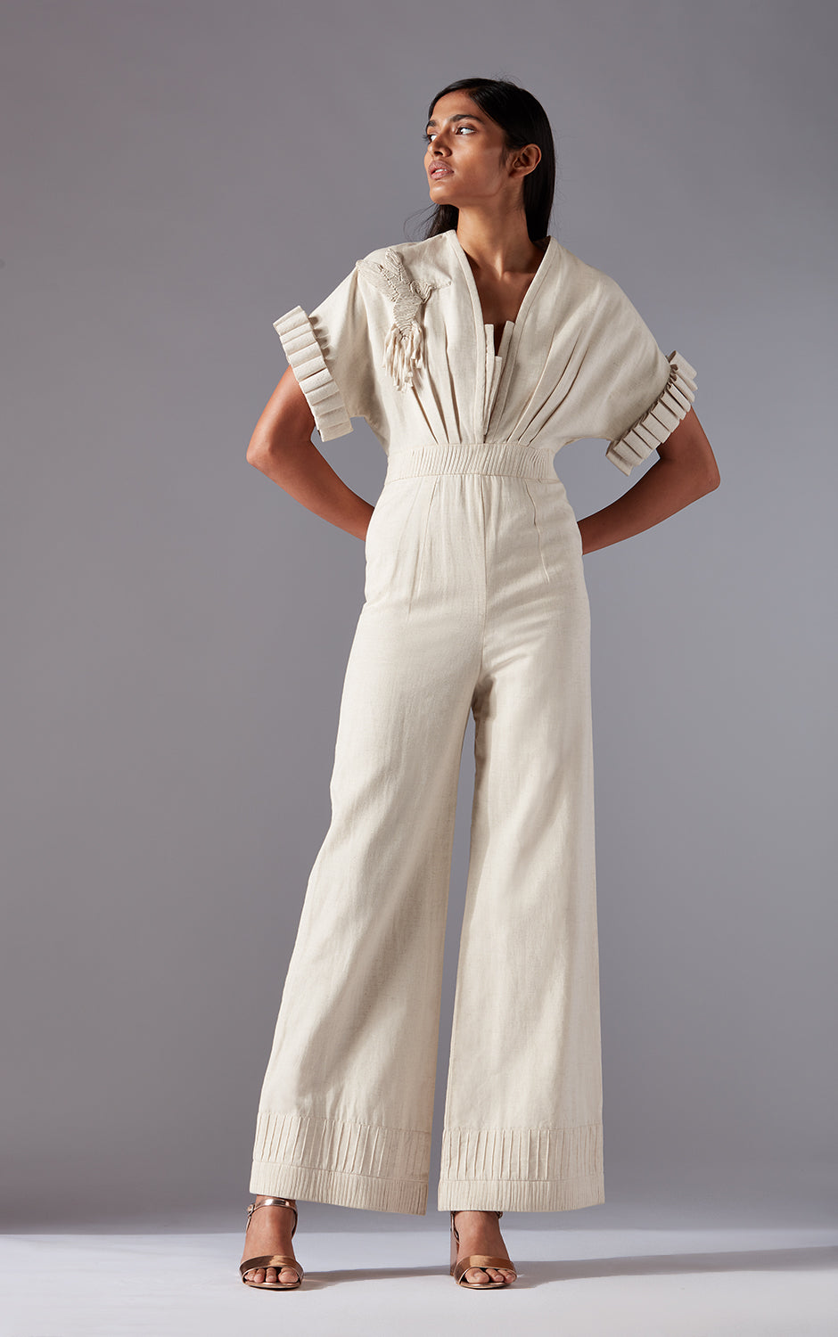 Modern khadi jumpsuit for women with sculpted sleeves, hummingbird motif, and waist pleating, offering a stylish and unique look