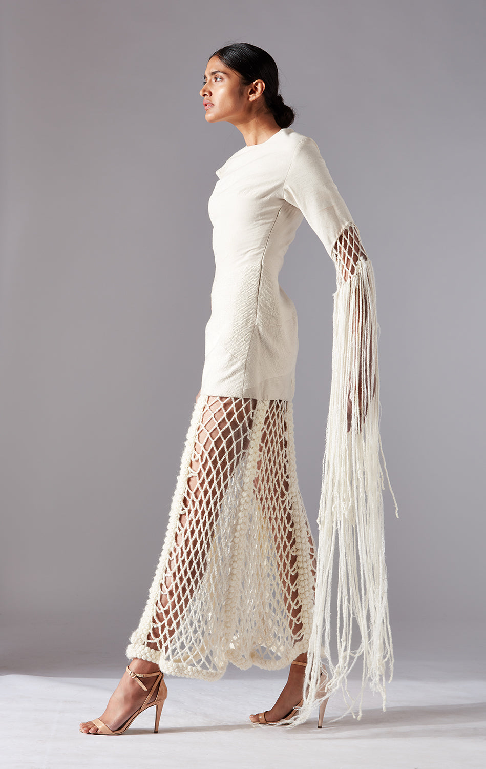 Side view of the Collage Crochet Gown, showcasing the flowing design and textured fabric