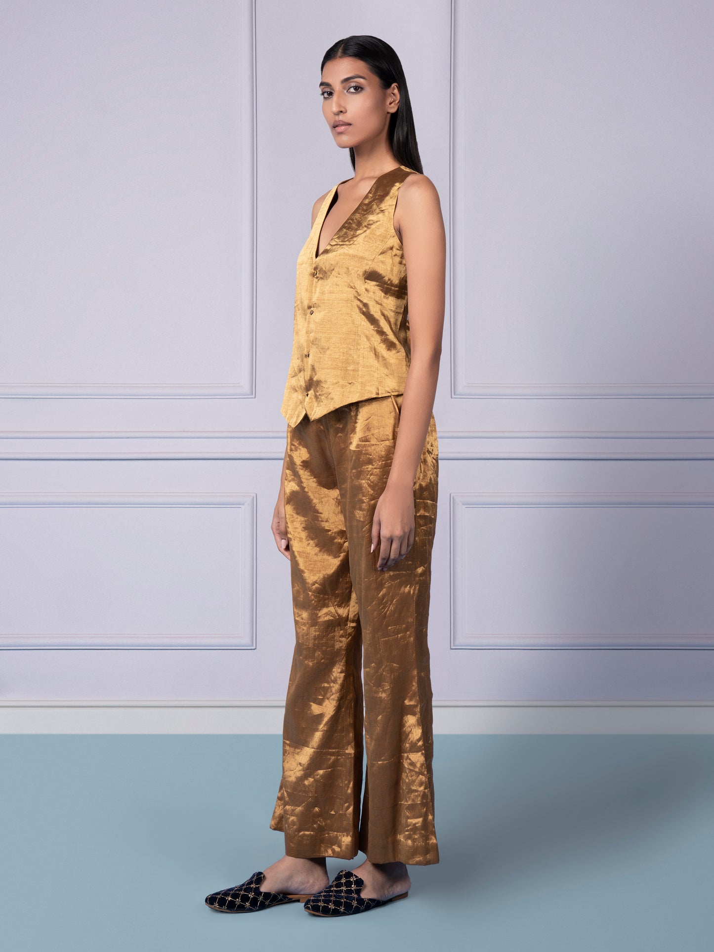 Side profile of a woman in the Gold Chanderi waistcoat and luxury flared pants, highlighting the chic and modern fit