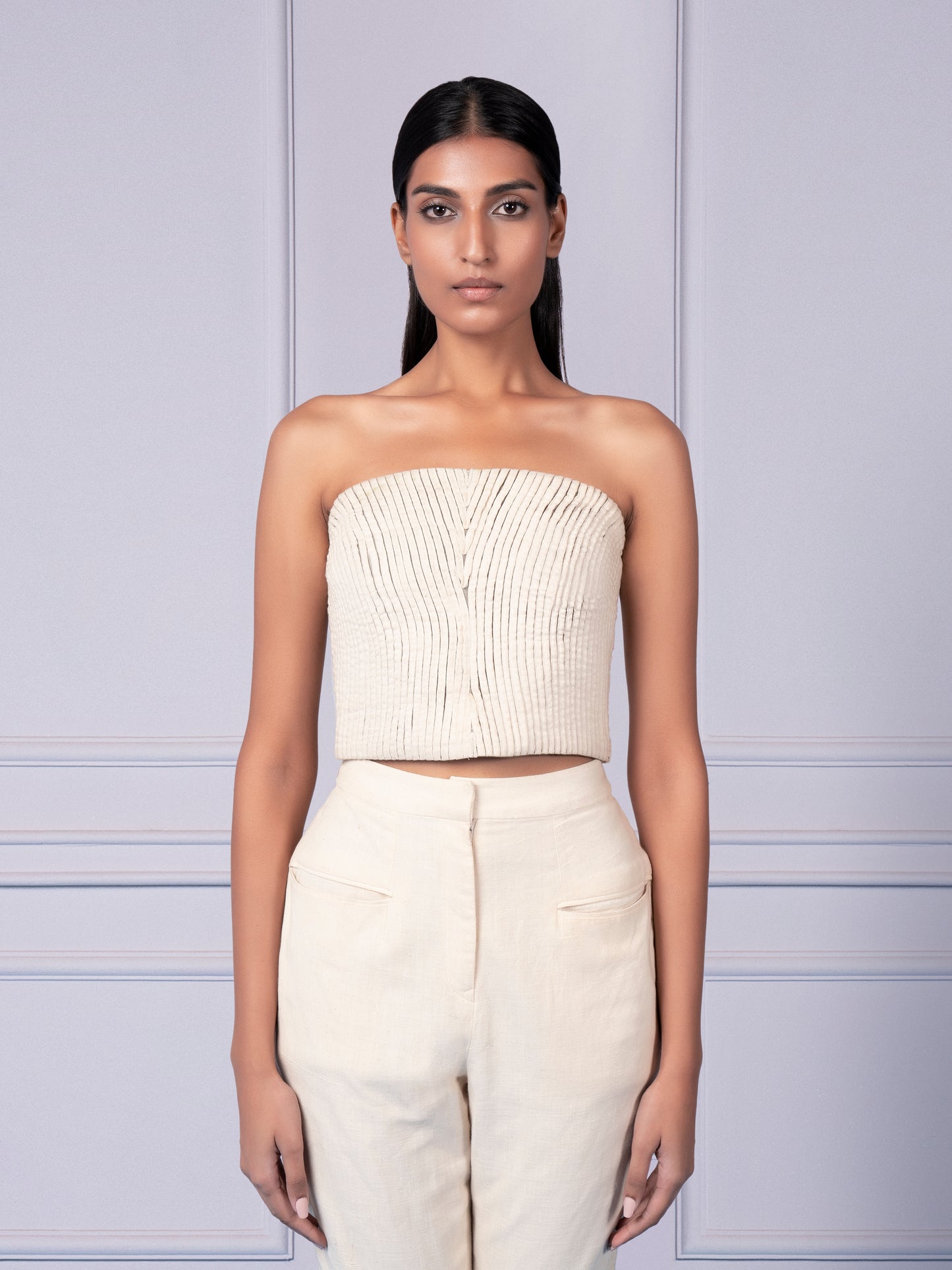 Close-up view of the strake pattern on the corset top and the cutout knee detailing on the narrow pants