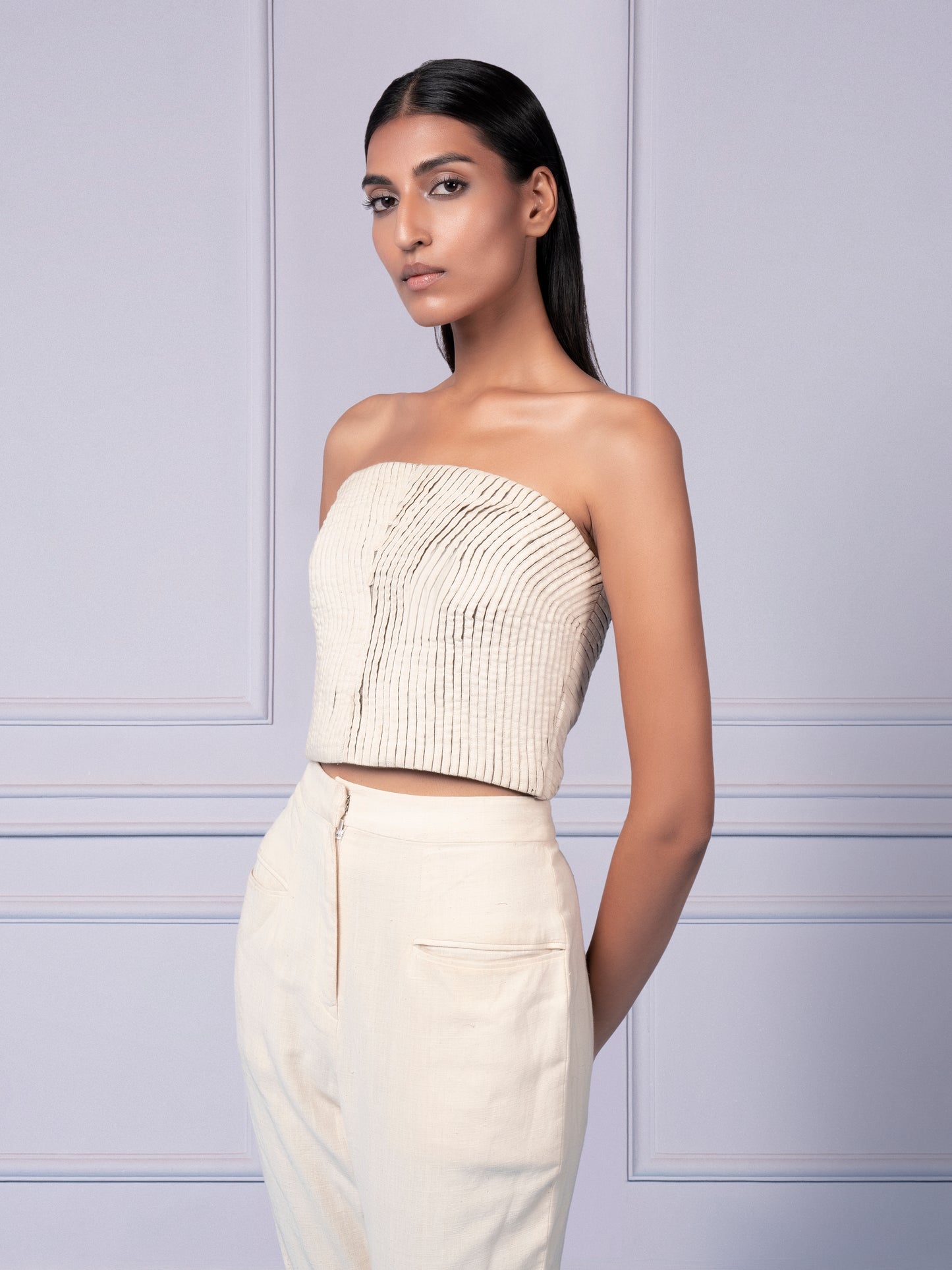 Focused image of the strake pattern on the corset top and the unique cutout knee detailing on the pants