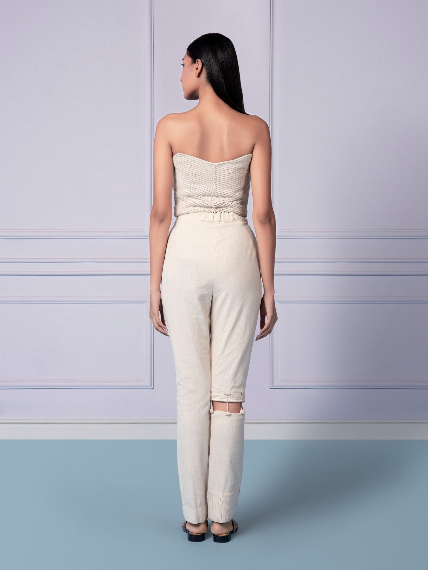 Back view highlighting the design of the corset top and the tailored fit of the narrow pants