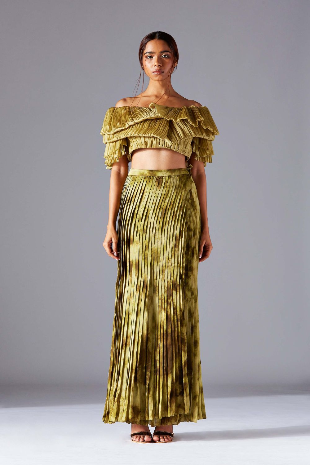 Modern off-shoulder blouse paired with a pleated wrap skirt, showcasing a chic and stylish outfit for women