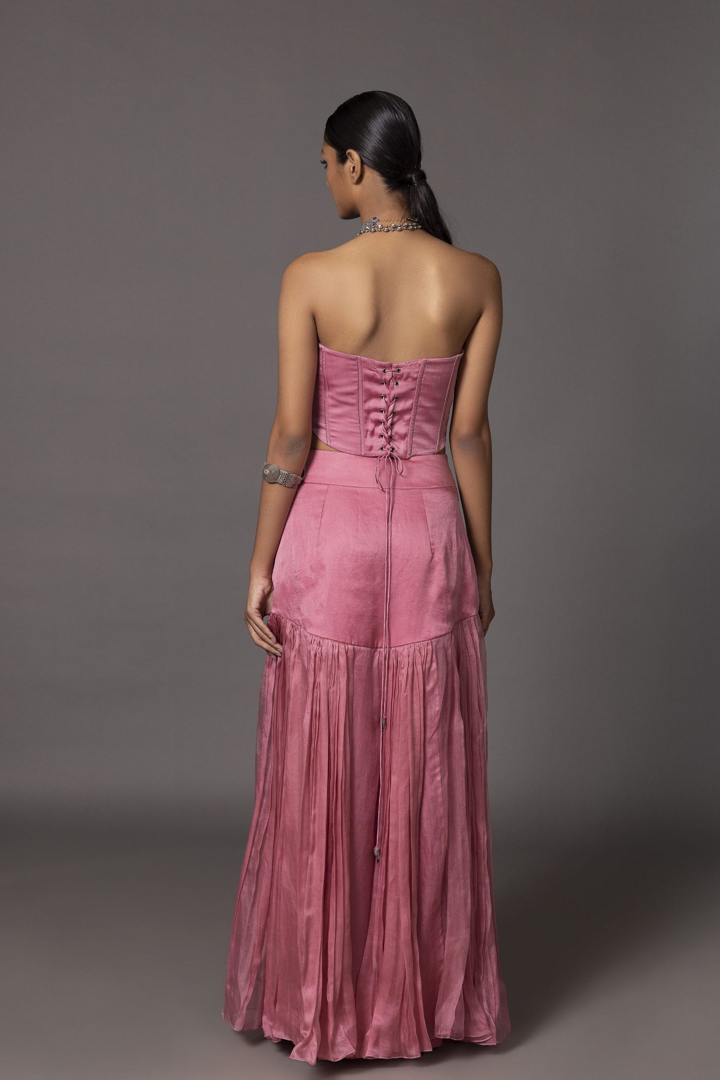 Back view of the Kaner Pink Corset Top & Skirt, showcasing the detailed embroidery and overall silhouette