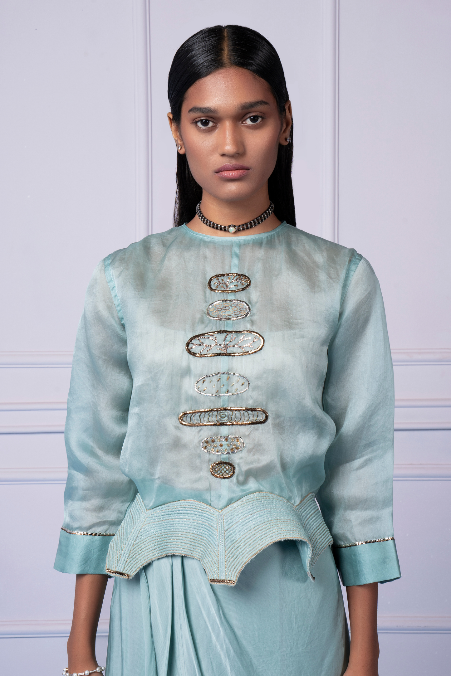 Close-up view of the metallic embroidery on the blouse, showcasing intricate details and fine craftsmanship