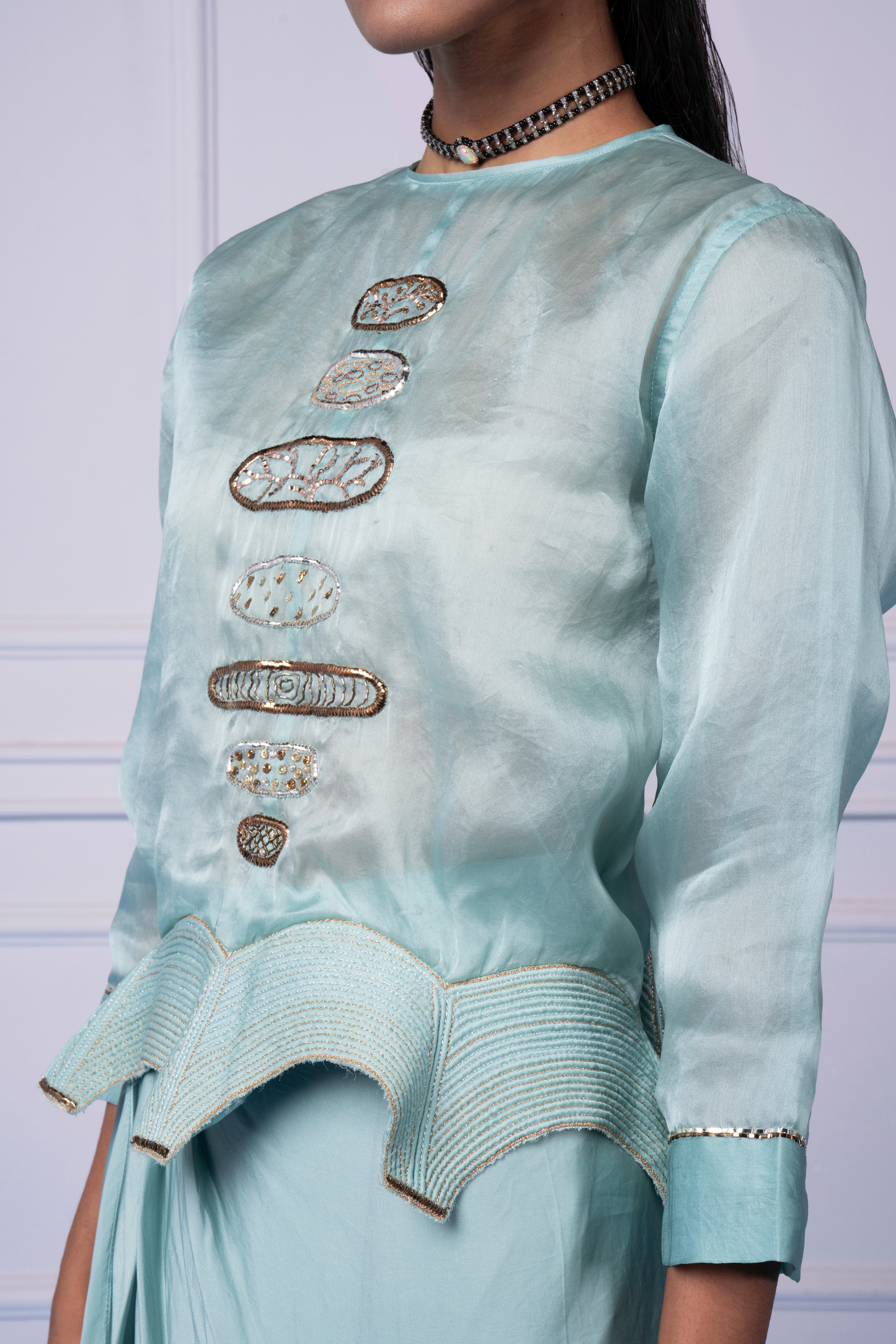 Focused view of the metallic embroidery on the blouse, highlighting the intricate design details and modern style