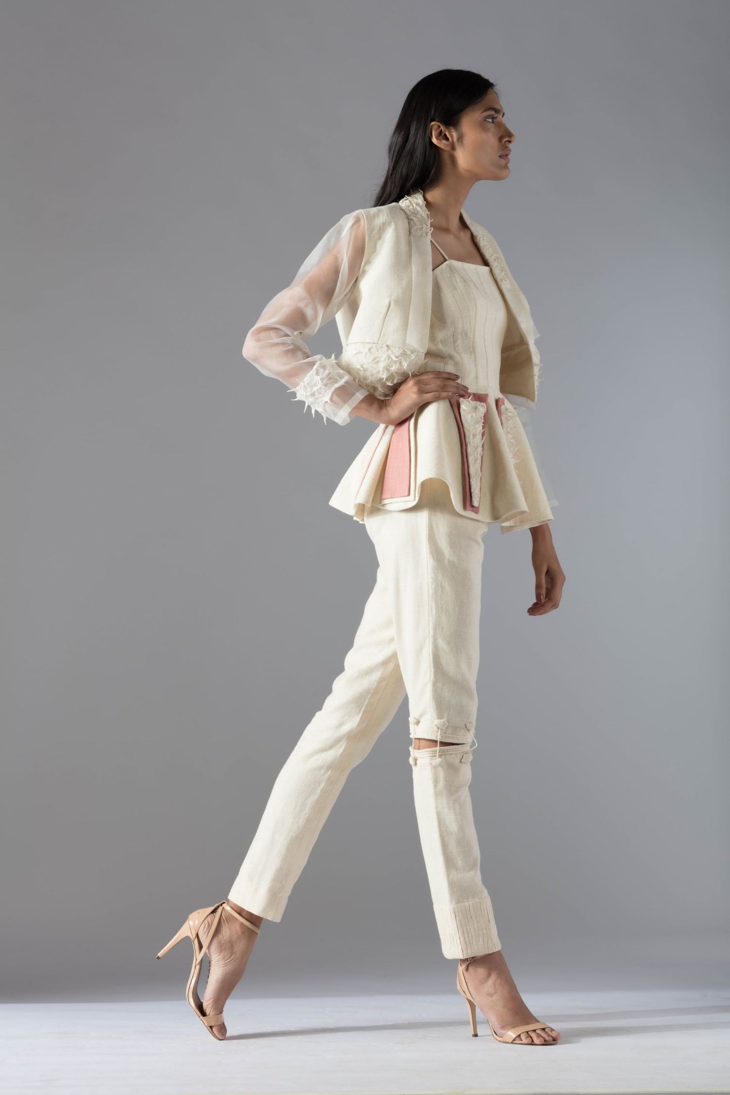 Side view of the peplum top and jacket pant set for women, highlighting the modern fit and stylish details