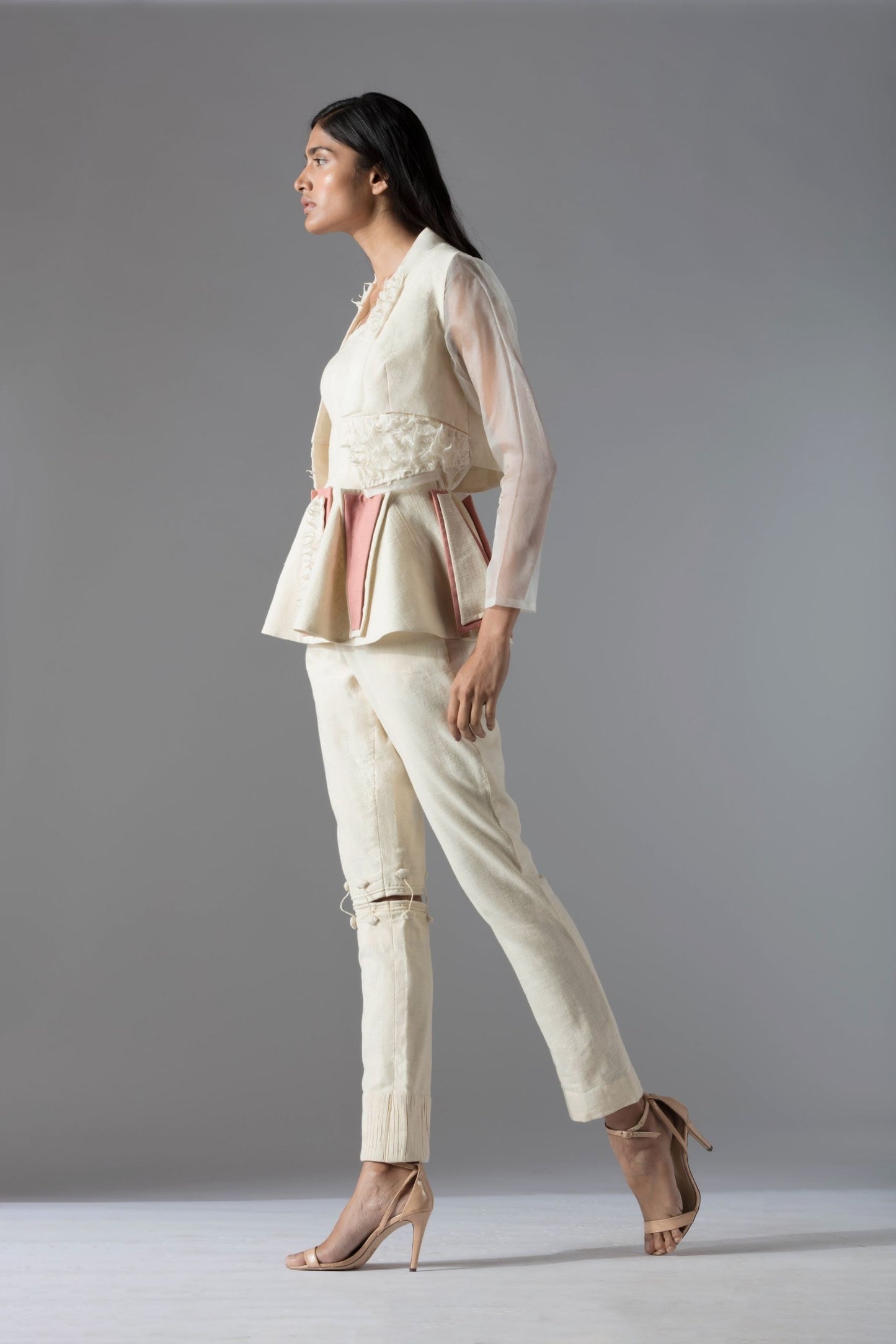 Side view of the peplum top and jacket pant set for women in organic khadi, showcasing the sleek silhouette and couture tailoring