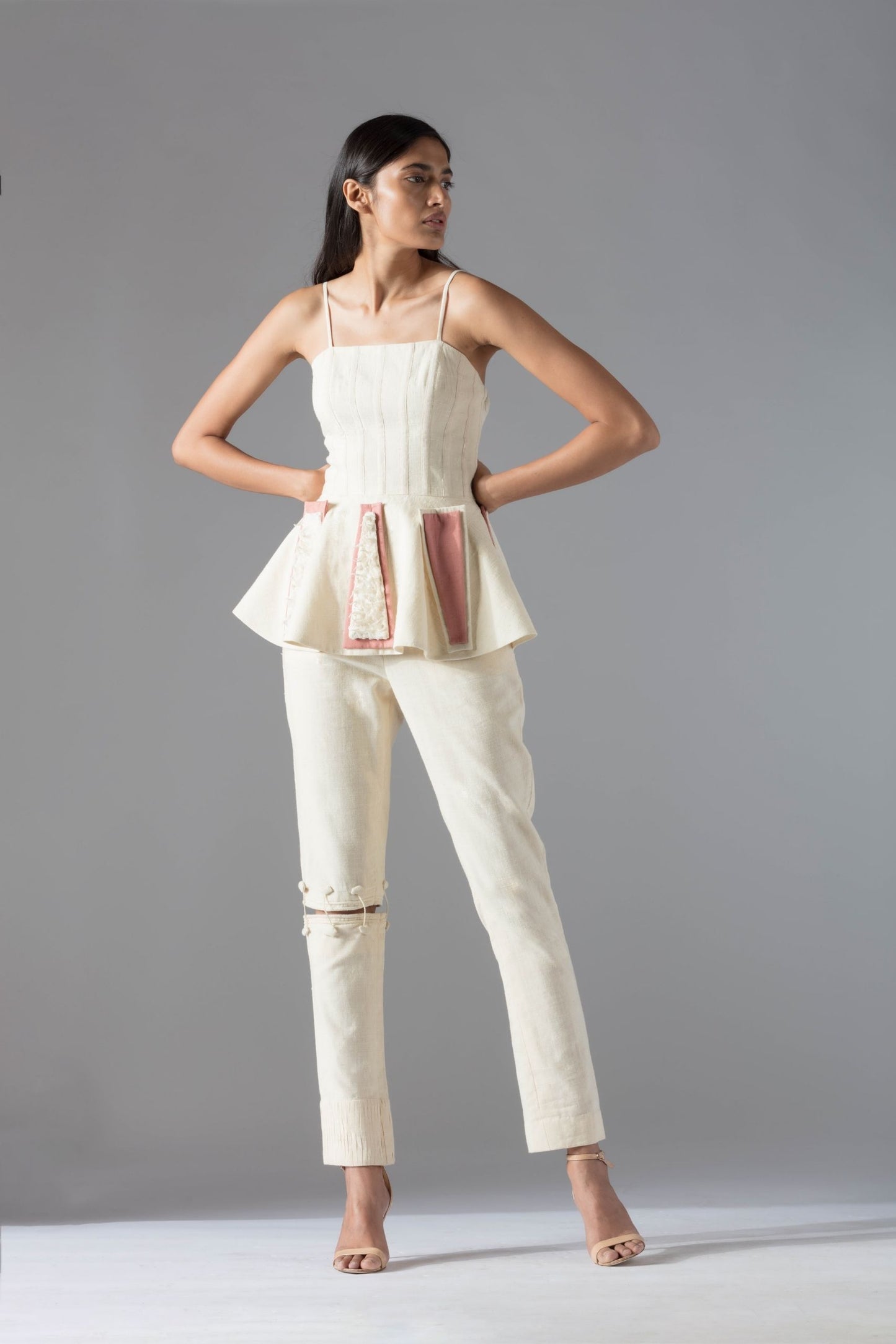 Full view of the peplum top and pant set, showcasing the elegant silhouette and chic couture design